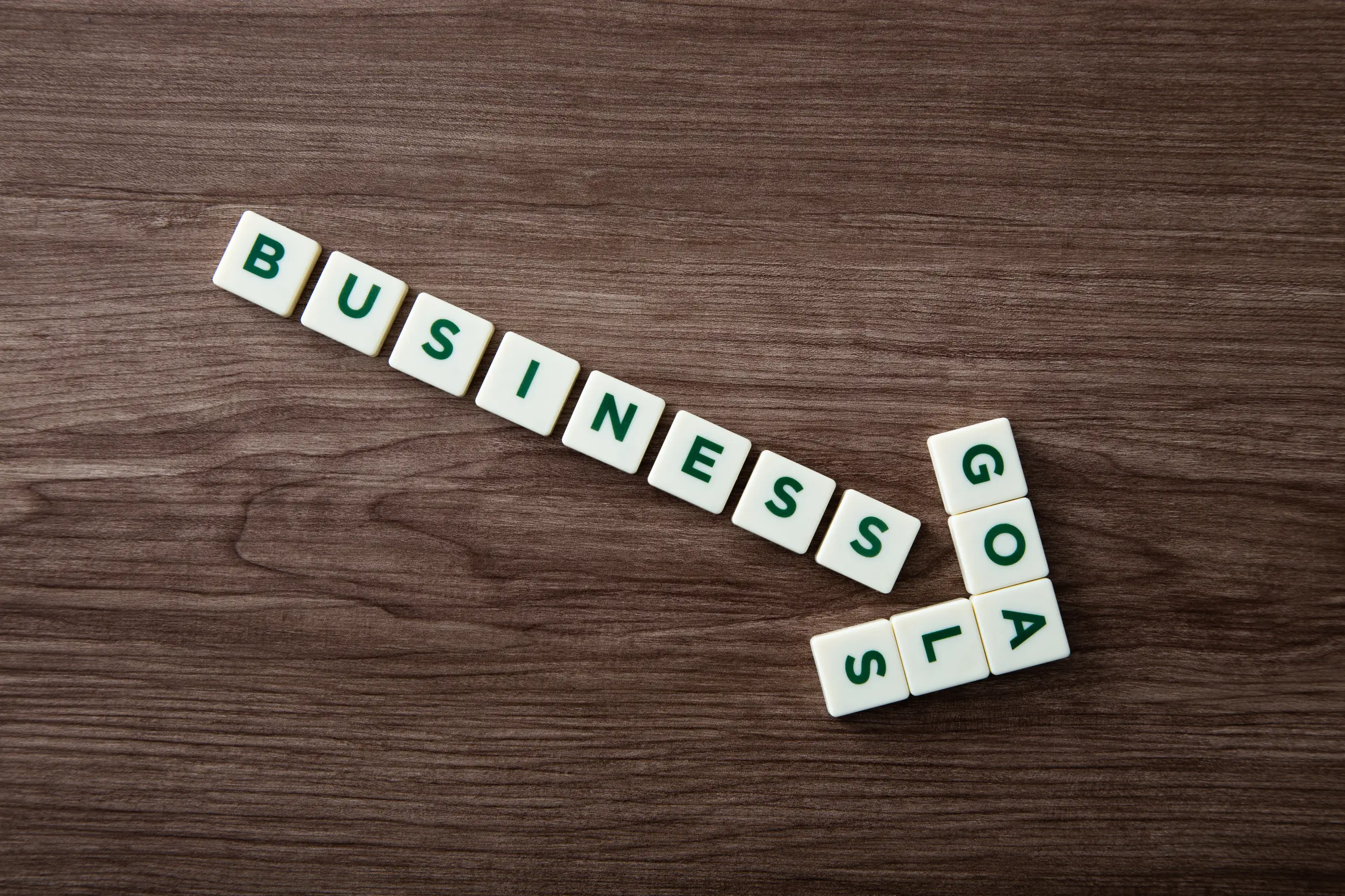 Scrabble-Buchstaben angeordnet als Pfeil mit dem Word "Business Goal"